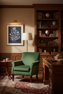 Elegant wall art featuring botanical prints in a cozy study with a green armchair and wooden desk