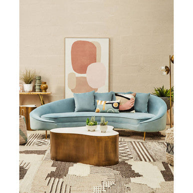 Contemporary wall art by Orsina displayed above a stylish blue sofa in a modern living room setting