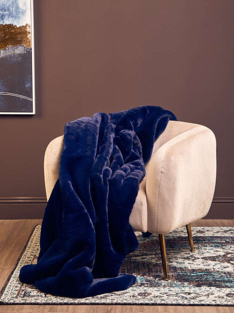 Orsina Navy Blue Fur Throw Draped Over a Modern Velvet Chair for Cozy Home Decor