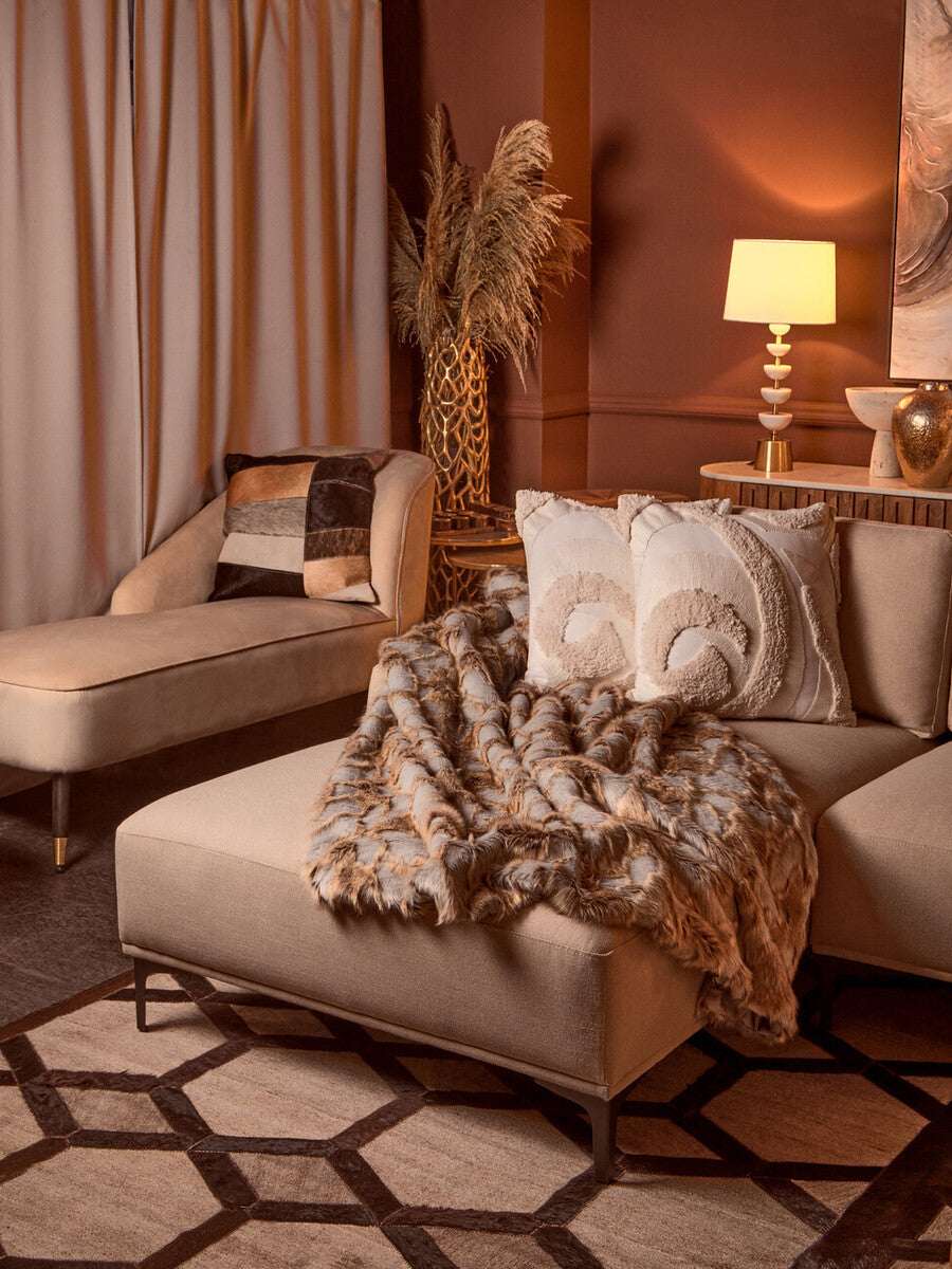 Luxurious Orsina Fur Throw draped on a modern beige chaise lounge in a stylish living room setting