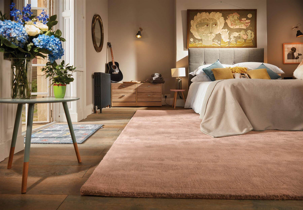 Spacious bedroom featuring a soft luxury rug in a neutral tone, complementing stylish decor