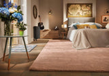 Spacious bedroom featuring a soft luxury rug in a neutral tone, complementing stylish decor