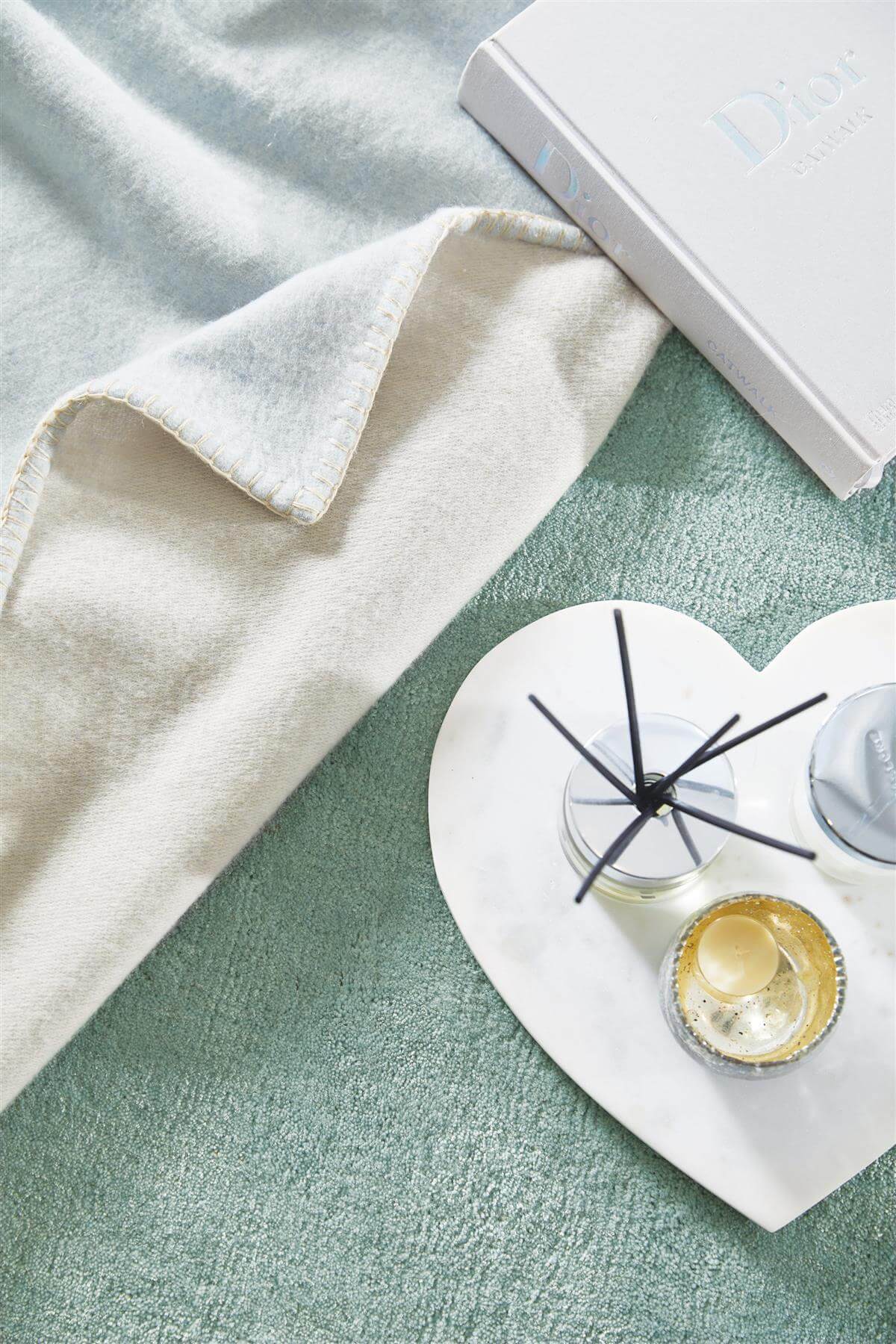 Soft Luxury Rug in muted tones with decorative items arranged for a stylish home aesthetic