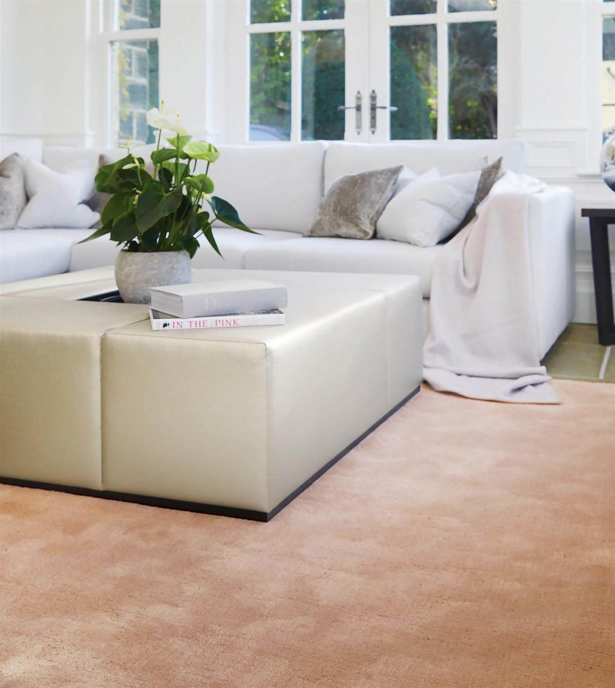 Elegant luxury rug in soft peach, enhancing a modern living room with natural light