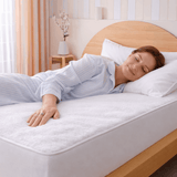 SHEET STORY Mattress Protector on a bed with a woman peacefully sleeping for added comfort
