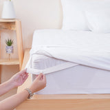 SHEET STORY Mattress Protector being secured on a mattress with elastic straps for a perfect fit