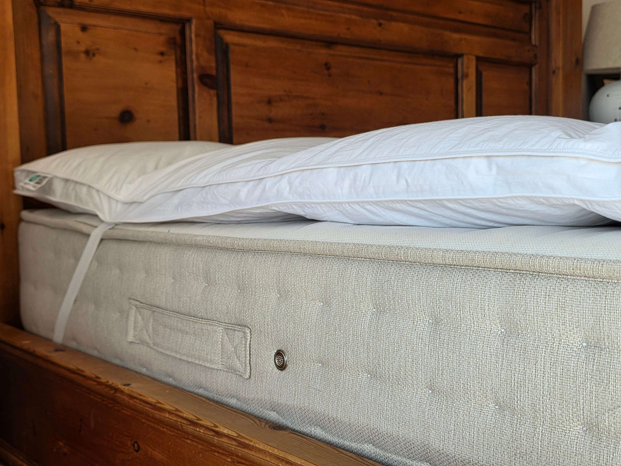 PillowPillow Mattress Topper positioned on a plush bed for enhanced comfort and support