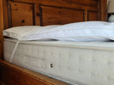PillowPillow Mattress Topper positioned on a plush bed for enhanced comfort and support