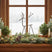 Metal Reindeer Christmas decoration accentuating a festive window display with greenery and lights
