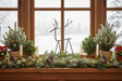 Metal Reindeer Christmas decoration accentuating a festive window display with greenery and lights