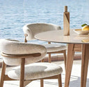 Stylish Nisu Home chair with soft upholstery next to a modern round table and decorative items