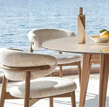 Stylish Nisu Home chair with soft upholstery next to a modern round table and decorative items