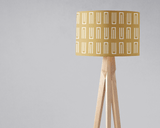 Shadow Bright stylish lampshade in gold geometric pattern on a wooden tripod lamp