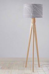 Contemporary lampshade by Shadow Bright with geometric pattern on a wooden tripod floor lamp