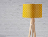 Shadow bright yellow patterned lampshade on a modern wooden lamp stand