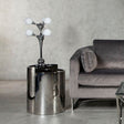 Orsina modern Table Lamp with four glass globes on stylish chrome base beside a grey sofa
