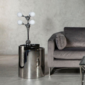 Orsina modern Table Lamp with four glass globes on stylish chrome base beside a grey sofa