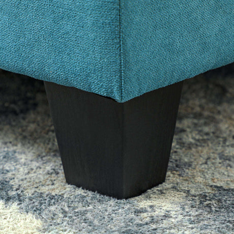 Close-up of a Modula Sofa leg with a dark wood finish against a soft rug
