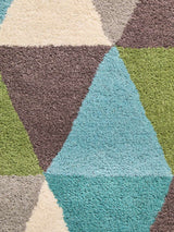 Orsina Multicoloured Rug featuring geometric patterns in shades of green, blue, and brown