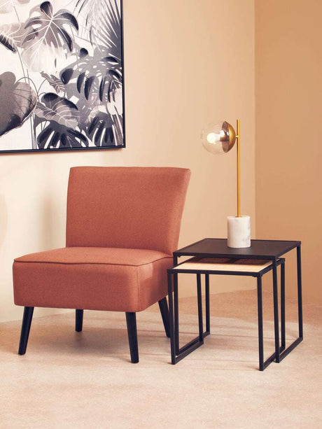 Orsina Nest of Tables in black metal with modern design, beside a stylish armchair and lamp