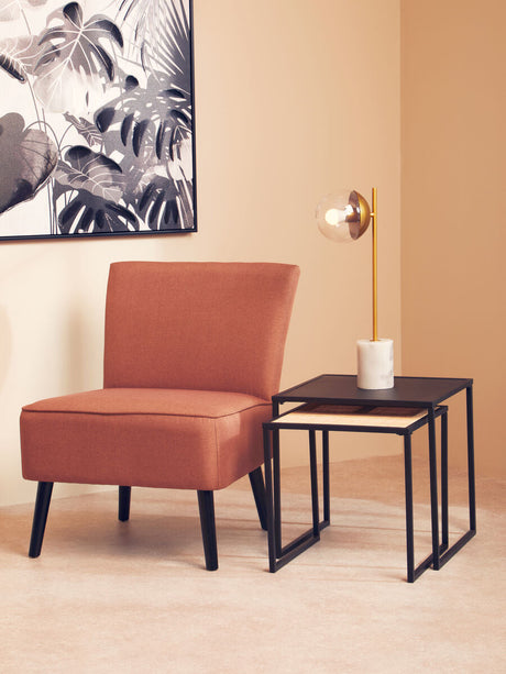 Orsina Nest of Tables in black metal with modern design, beside a stylish armchair and lamp