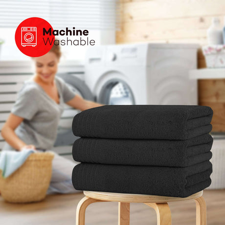 Set of OLIVIA ROCCO black bath sheets stacked, featured in a laundry room setting