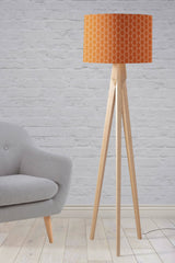 Shadow Bright lampshade in bright orange on a stylish floor lamp next to a grey sofa