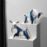 Colourful decorative cow ornaments in blue and orange from Nisu Home for stylish interior accents