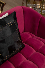 Orsina Patchwork Cushion in Black with Decorative Studs on a Plush Pink Sofa
