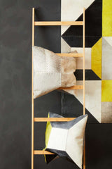 Stylish Orsina Patchwork Cushion in geometric design displayed on a wooden ladder