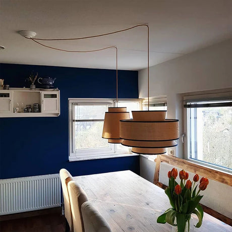 Stylish Nisu Home Pendant Light in a modern interior with a wooden dining table and tulips