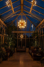 Stunning Orsina pendant light illuminating a modern conservatory with lush greenery