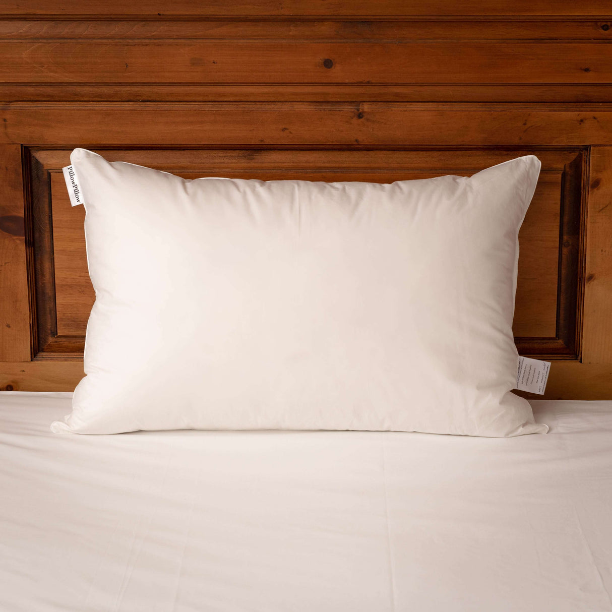 Soft and comfortable Pillow by PillowPillow placed on a wooden headboard for restful sleep