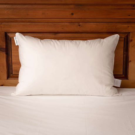 Soft and comfortable Pillow by PillowPillow placed on a wooden headboard for restful sleep