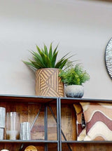 Orsina planter with a geometric design, featuring a succulent and a fern on a shelf