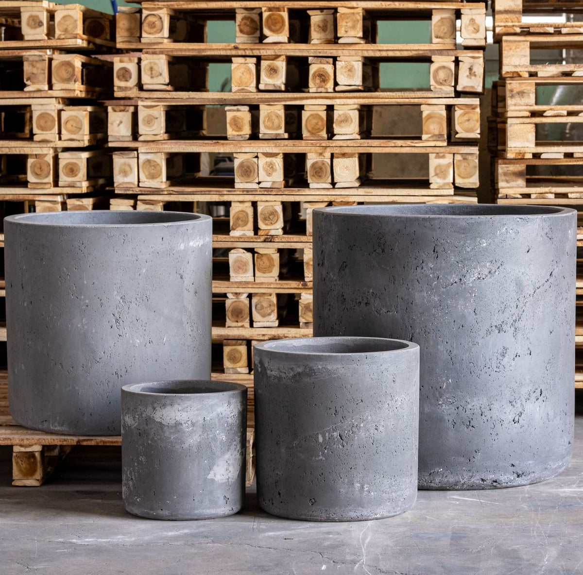 Set of four grey concrete planters in various sizes for indoor and outdoor gardening