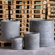 Set of four grey concrete planters in various sizes for indoor and outdoor gardening