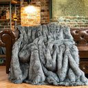 Luxurious grey faux fur throw from Nisu Home draped over a leather sofa for added warmth and style