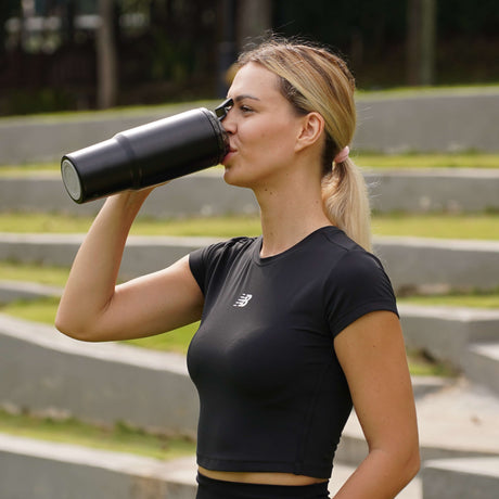 Fridja Portable Blender in use, a woman drinking from the blender outdoors after exercising