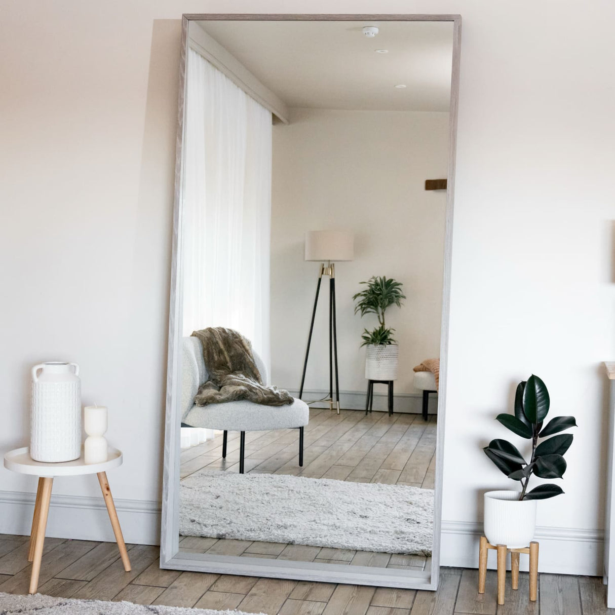 Jobu Home Rectangle Mirror with a wooden frame reflecting modern living room decor
