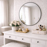Elegant Circle Mirror by Jobu Home above a stylish vanity table with flowers and makeup accessories