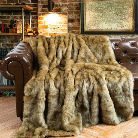 Luxury faux fur throw in warm brown tones draped over a leather sofa for cosy home decor