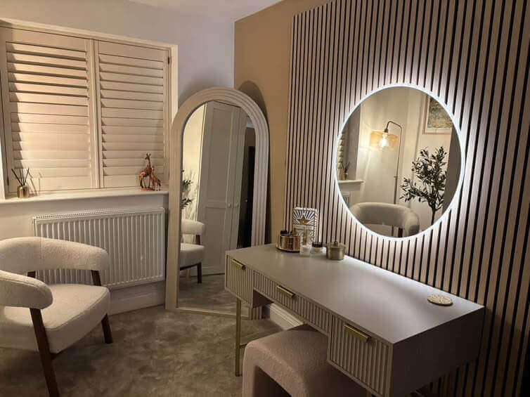 Elegant round mirror with LED lighting above a stylish dressing table in a chic room