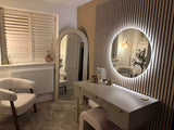 Elegant round mirror with LED lighting above a stylish dressing table in a chic room