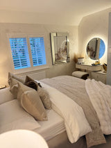 Stylish Round Mirror above a vanity in a modern bedroom with elegant decor