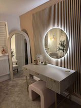 Stylish round mirror with built-in lighting above a modern vanity desk in a chic interior