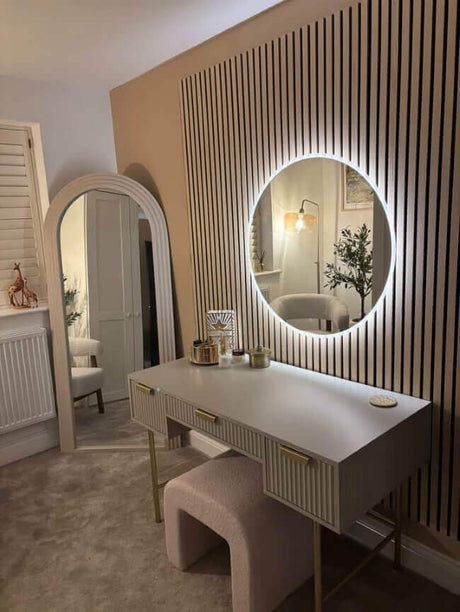 Stylish round mirror with built-in lighting above a modern vanity desk in a chic interior