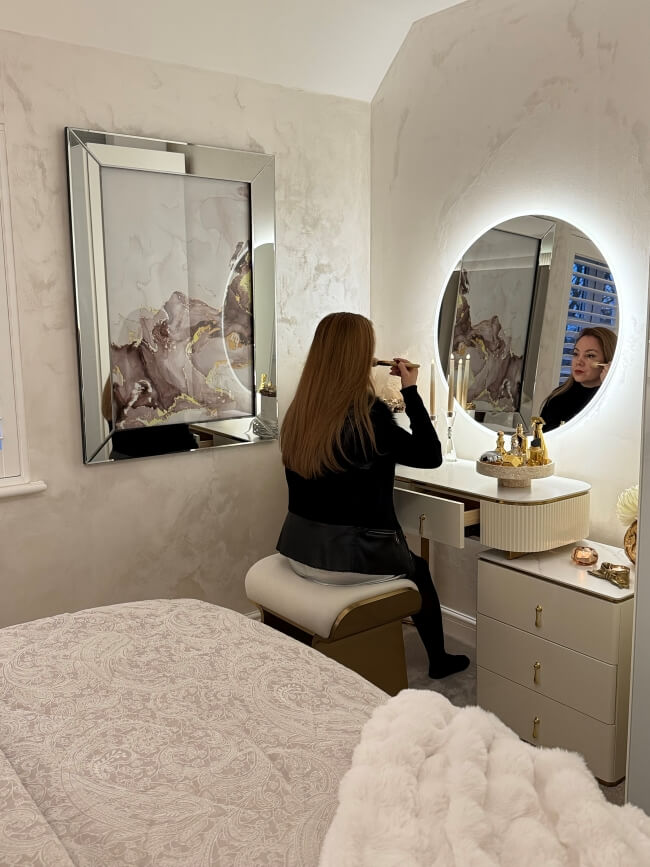 Elegant round mirror with LED lights above a stylish vanity in a chic bedroom setting