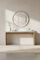 Stylish round mirror above a wooden console table in a minimalist interior setting