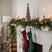 Rustic Bough Tree decoration on a mantel with candles and festive stockings for Christmas room decor